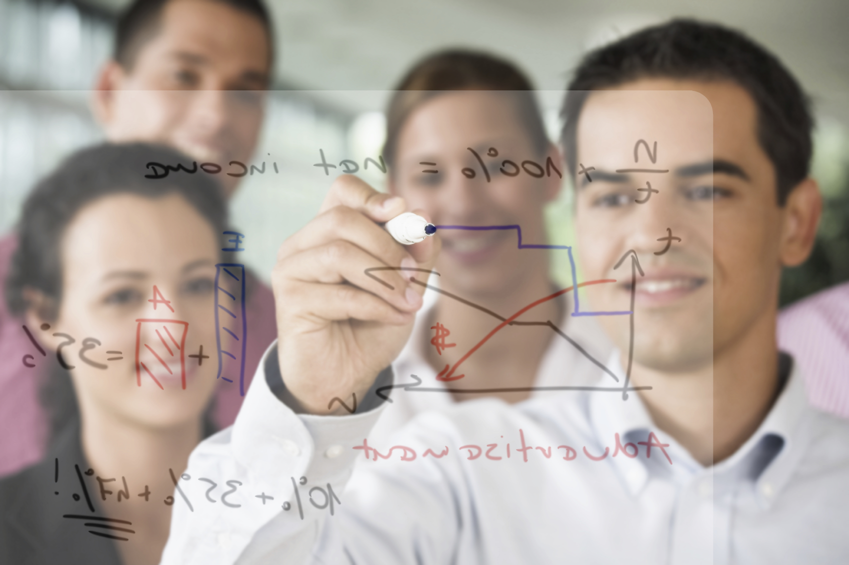 Team zeichnet Diagramme und Formeln mit Marker auf Glaswand im Büro